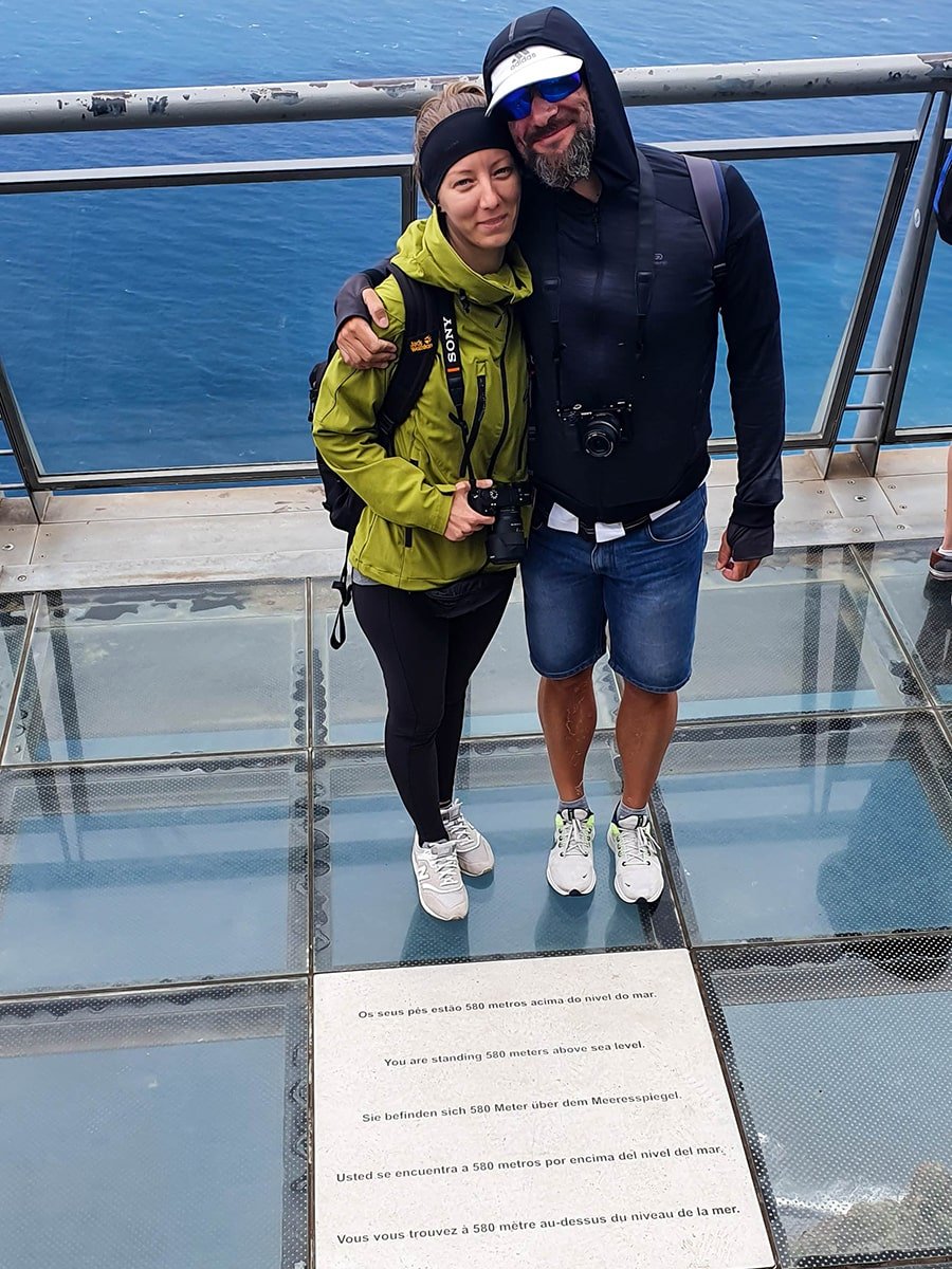A couple standing on the glass floor at Cabo Girao sky walk