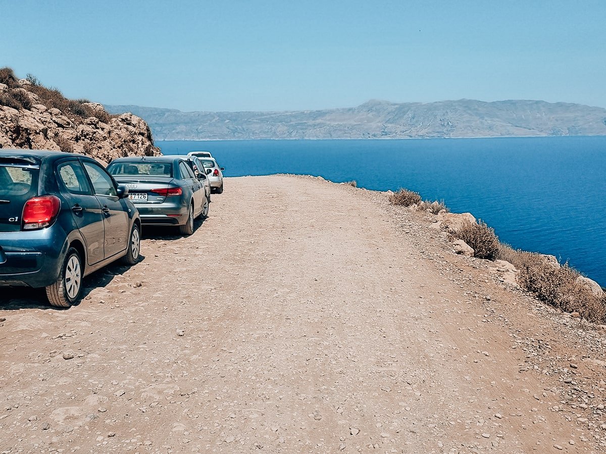 Dusty road and cars near the beach