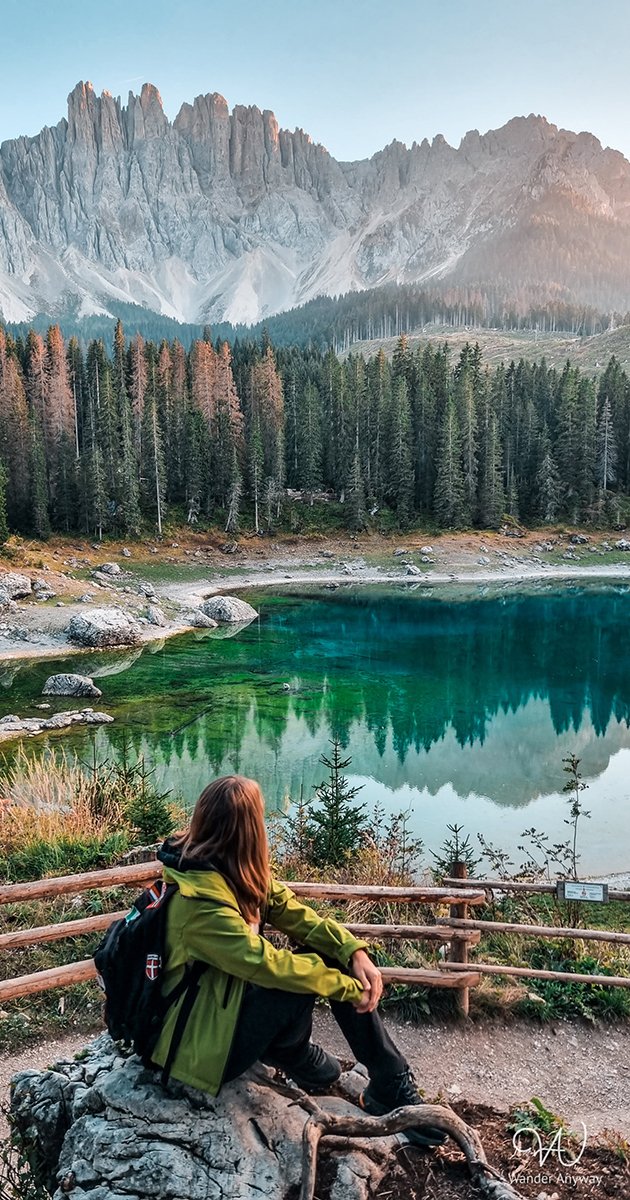 Backpacker sitting on a rock with an amazing lake view
