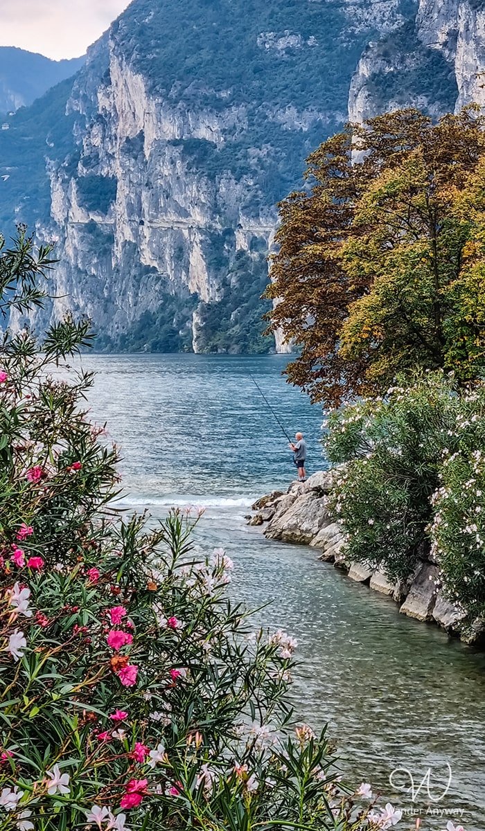Picturesque Riva del Garda with a fisherman and flowers