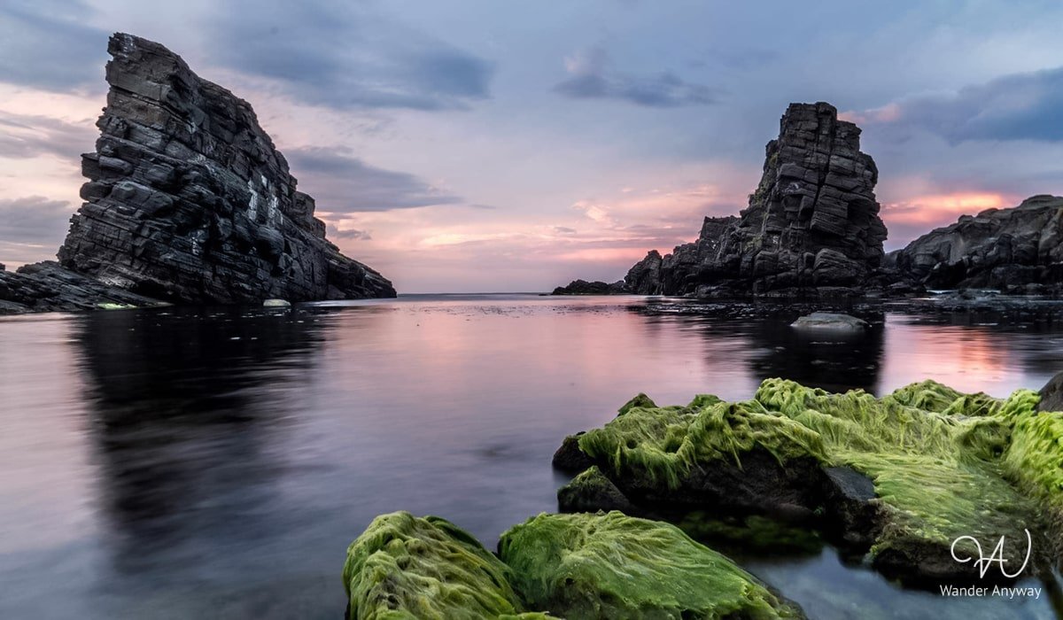 Silhouette of the Stone Ships at sunset, creating a dramatic and picturesque scene against the colorful sky.