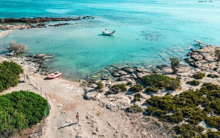 Aerial view of Elafonisi Beach, showcasing its unique pink sand shoreline and vibrant blue waters.