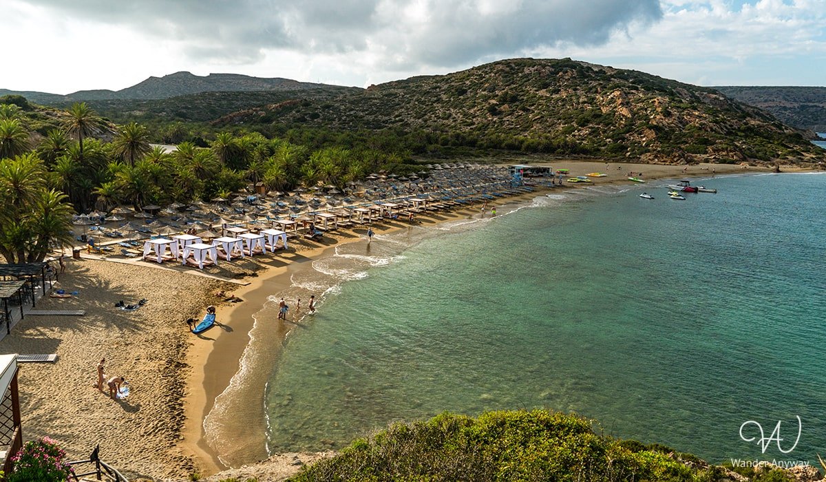 Golden sands of Vai Beach, surrounded by Europe's largest palm forest and clear blue skies.