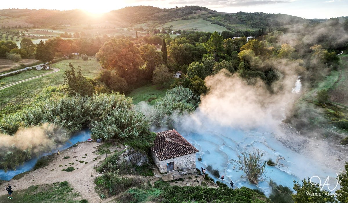 Breathtaking view of Cascate del Mulino with cascading thermal pools and the open landscape of Tuscany