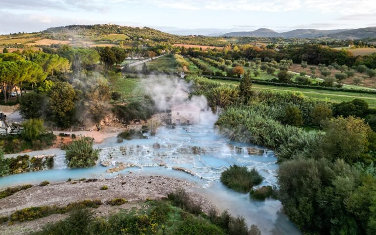 Aerial view of Cascate del Mulino thermal baths in Tuscany, featuring natural limestone pools and scenic countryside