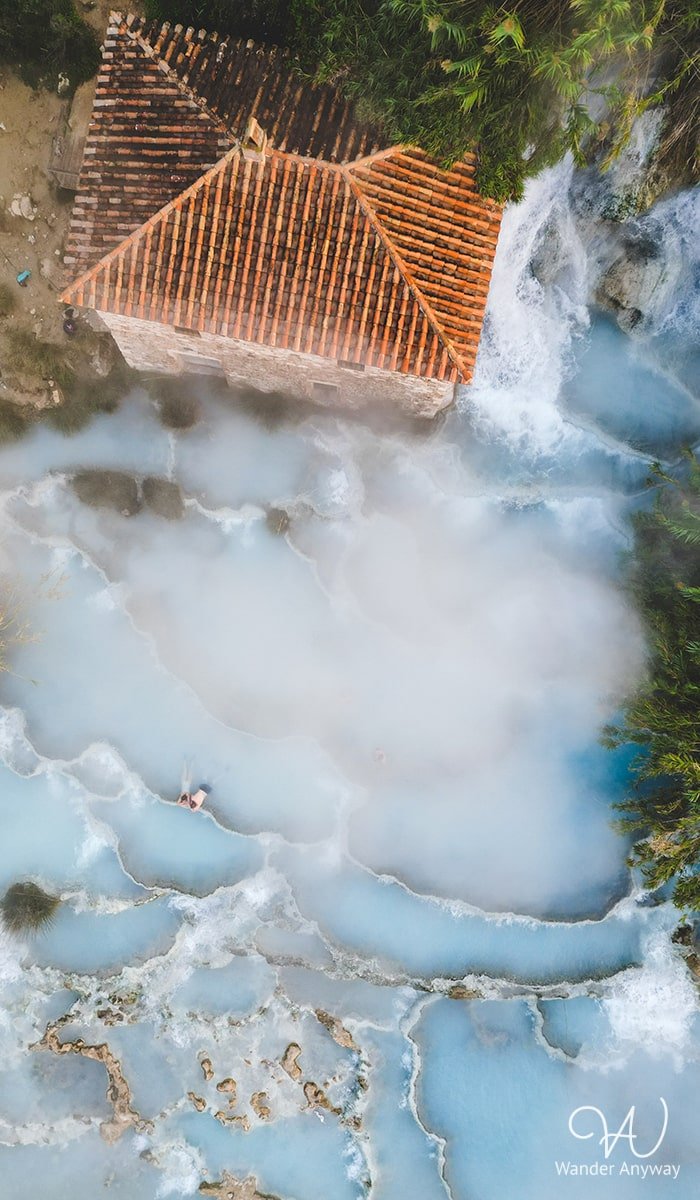 People enjoying the mineral-rich waters at Cascate del Mulino hot springs