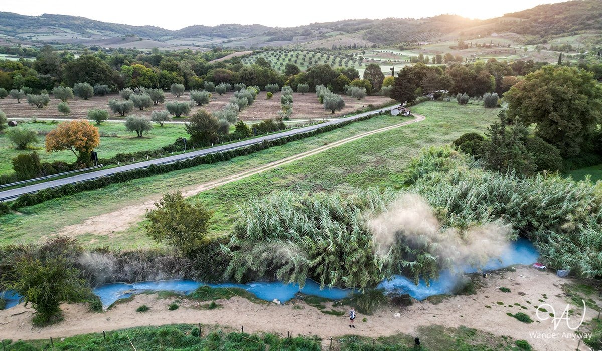 Turquoise thermal water nestled in Tuscany's green landscape