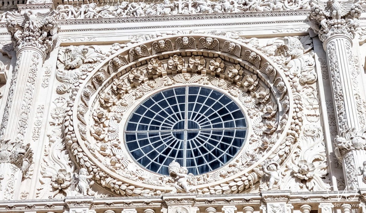 The Basilica di Santa Croce in Lecce, a Baroque masterpiece with an intricately carved facade of cherubs and floral motifs.