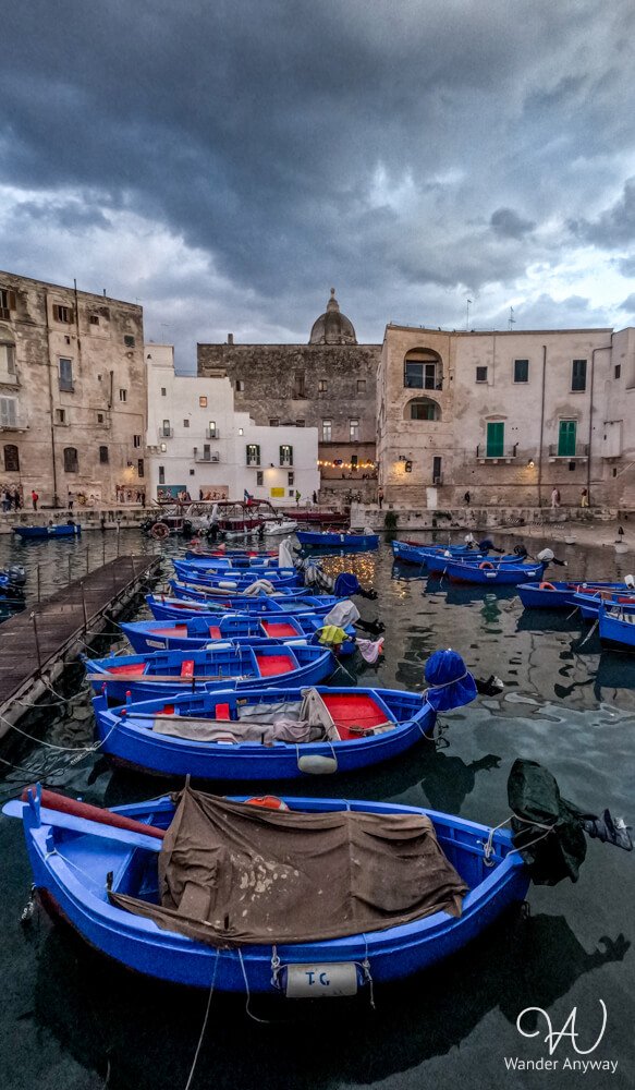Traditional boats docked in Monopoli’s Porto Vecchio under a soft golden sunset.