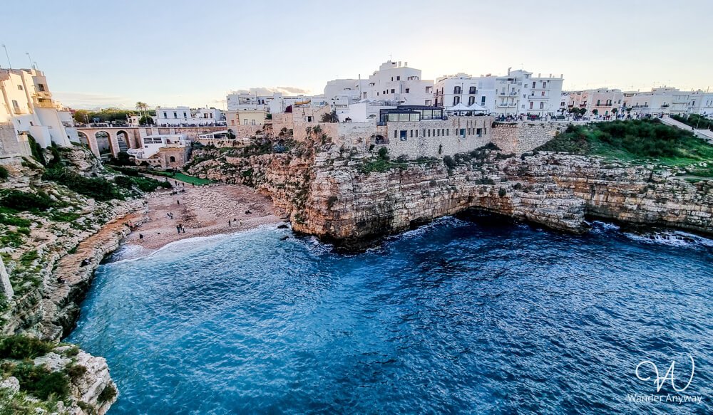 Iconic Lama Monachile cove in Polignano a Mare, framed by cliffs and the Roman bridge above.