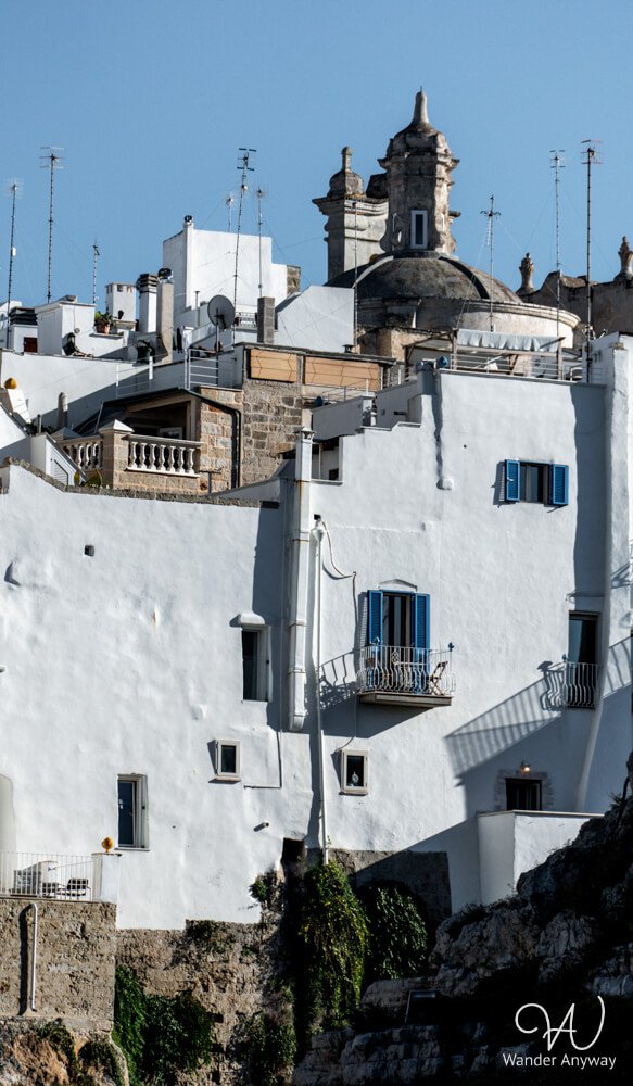 Cliffside view of Polignano a Mare with white houses.