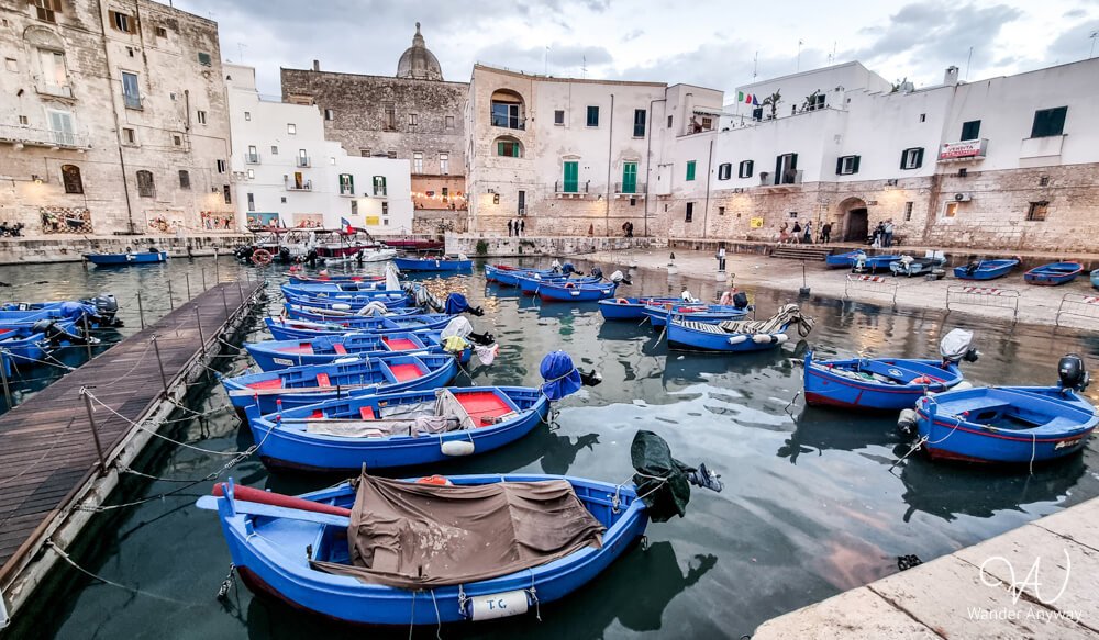 A peaceful view of Monopoli’s old harbor with boats floating beside historic buildings