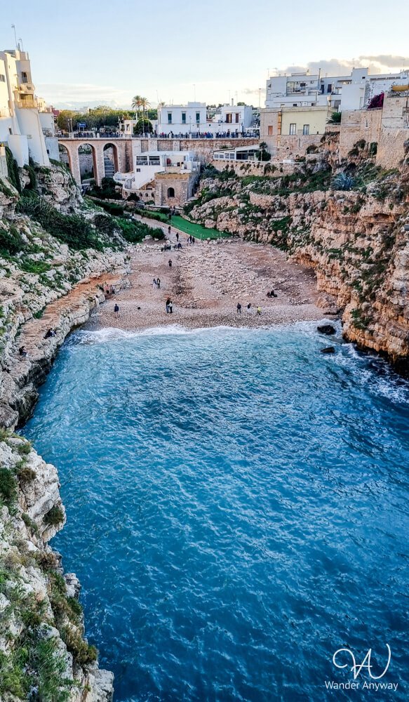 Lama Monachile beach nestled between dramatic cliffs and the Roman bridge in Polignano a Mare.
