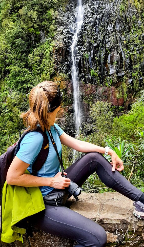 Hiker sitting beside Risco Waterfall along PR6.1 trail
