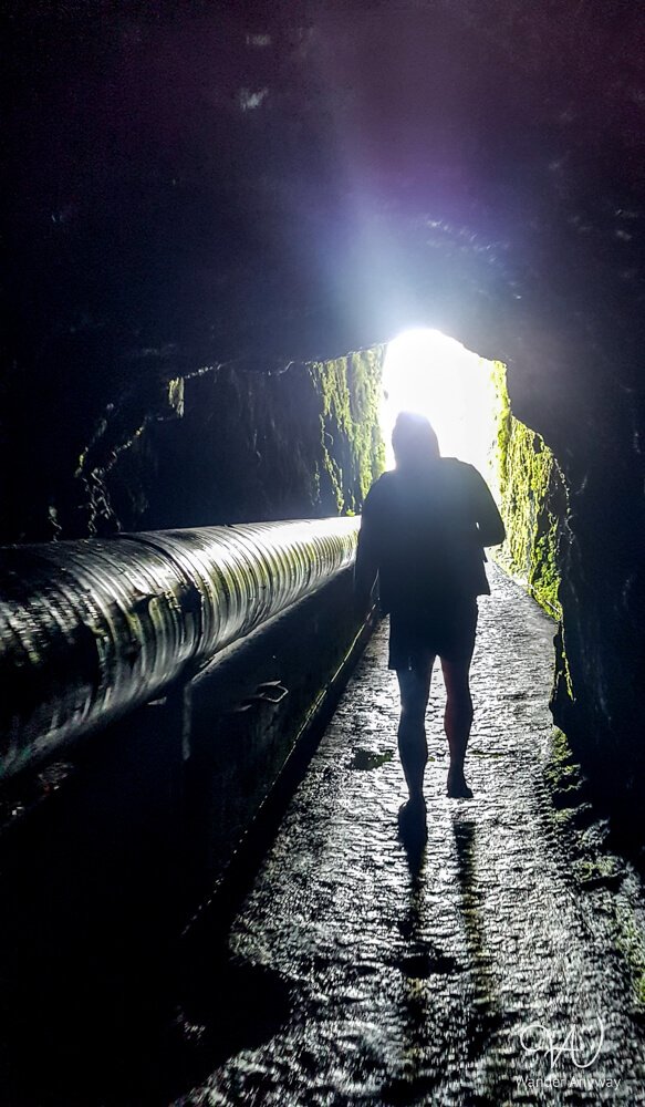 Silhouette of hiker inside the 800-metre tunnel to 25 Fontes trail