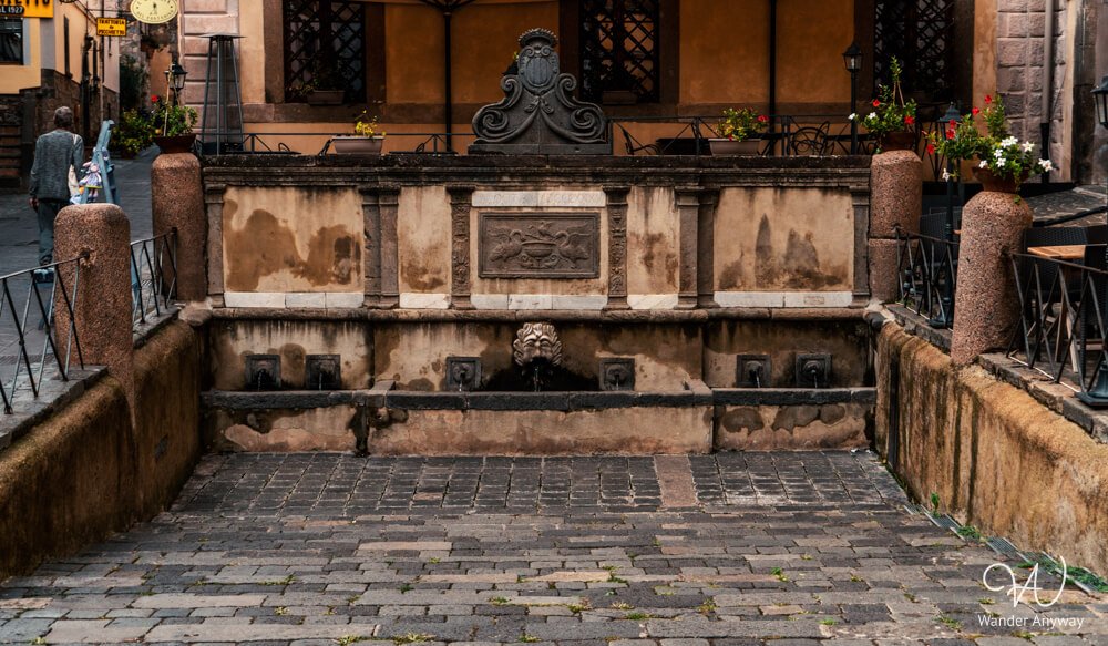 San Rocco Fountain set between historic buildings in Bolsena